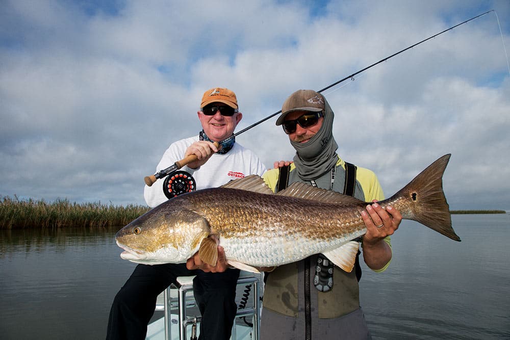 Fishermen holding redfish caught fly fishing